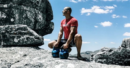 Coenzima Q10, importanza nello sport Sportivo si allena con kettlebell