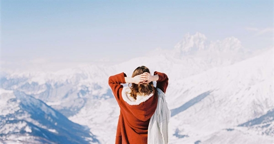 integratori-in-inverno-per-sistema-immunitario Donna assume integratori alimentari per rafforzare il proprio sistema immunitario durante l'inverno in montagna